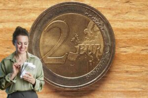 moneta da 2 euro e donna con banconote in euro in mano