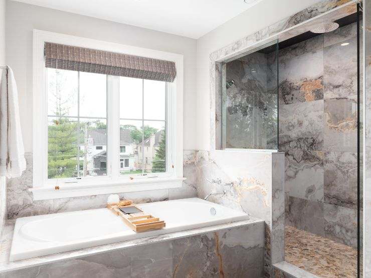 bagno moderno con rivestimento in pietra e doccia senza porte