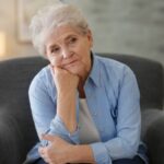 donna anziana in poltrona con espressione preoccupata