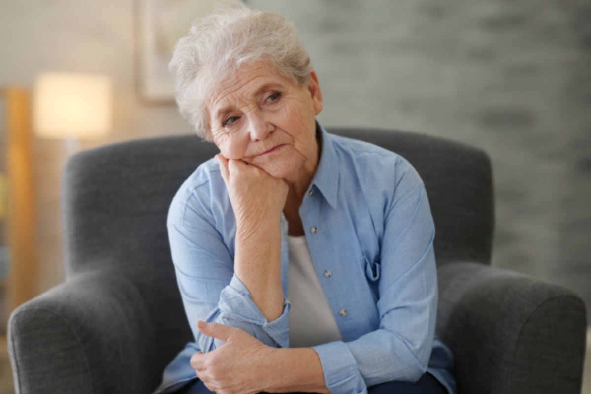 donna anziana in poltrona con espressione preoccupata