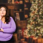 albero di natale addobbato con luci e donna che pensa