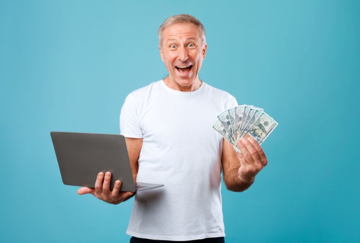 uomo che esulta con pc e soldi in mano con sfondo azzurro