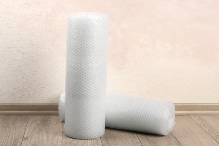 Dei rotoli di pluriball su un pavimento in una stanza