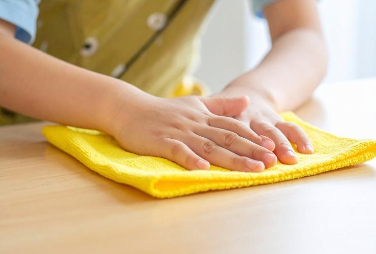 persona che passa il panno in microfibra su una superficie