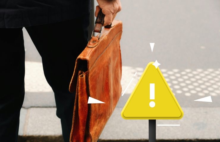 un signore che porta in mano una valigetta e un segnale di attenzione